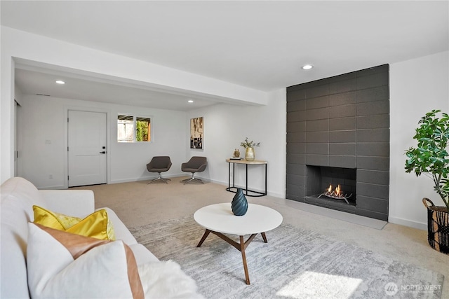 carpeted living area with a large fireplace, recessed lighting, and baseboards
