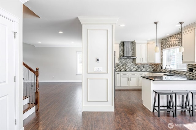 1226 57th Ct SE, Auburn, WA 98092 - kitchen with wall chimney exhaust hood, a sink, dark countertops, decorative backsplash, and a kitchen breakfast bar