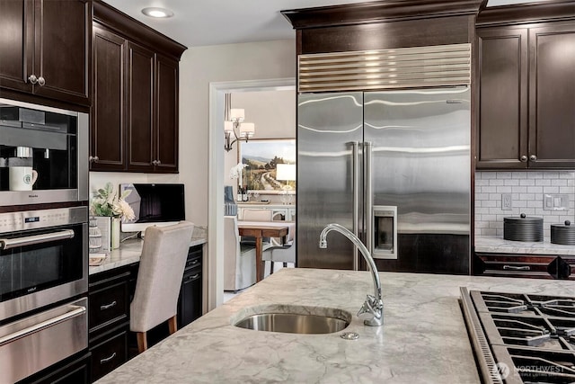 19016 NE 127th St, Redmond, WA 98052 - kitchen featuring stainless steel appliances, a sink, a warming drawer, decorative backsplash, and light stone counters