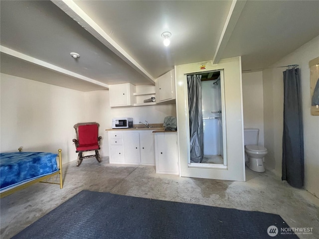 kitchen featuring white microwave, white cabinetry, unfinished concrete floors, open shelves, and a sink