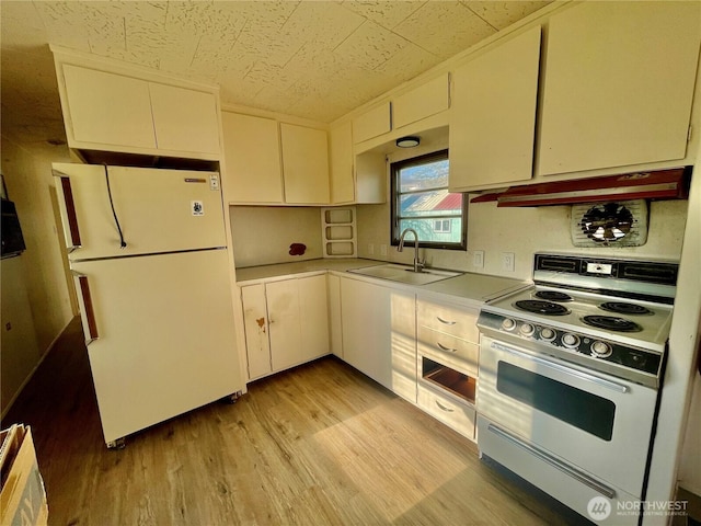 101 5th St, Starbuck, WA 99359 - kitchen with white appliances, a sink, light countertops, light wood finished floors, and under cabinet range hood