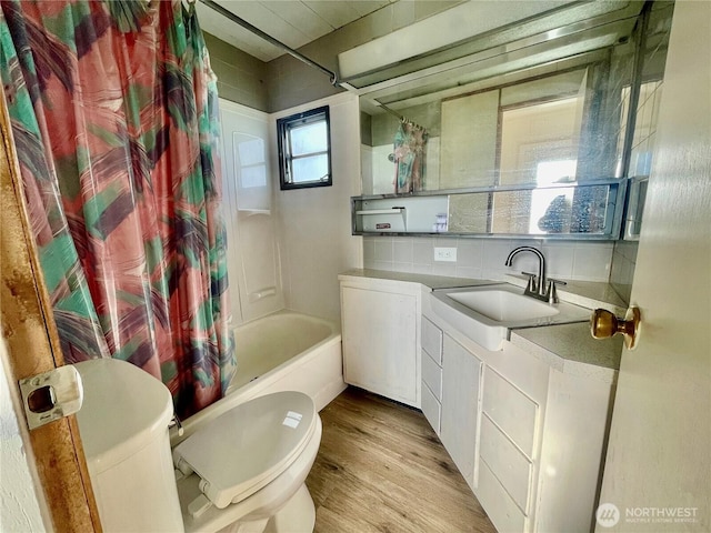 101 5th St, Starbuck, WA 99359 - bathroom featuring toilet, wood finished floors, shower / tub combo with curtain, backsplash, and vanity
