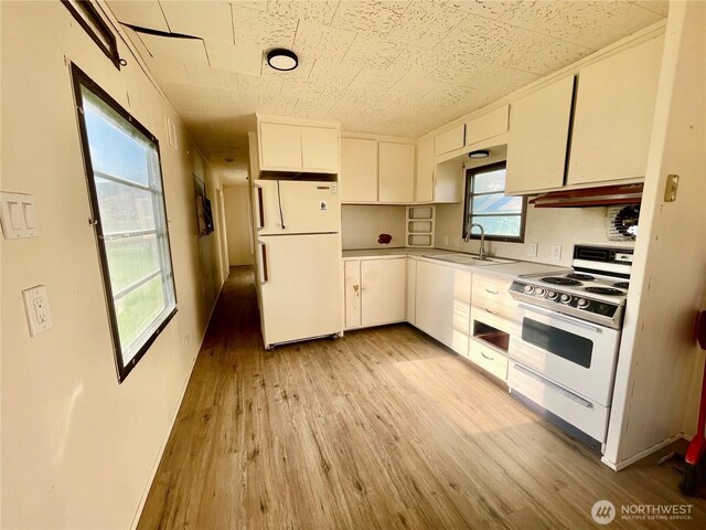 101 5th St, Starbuck, WA 99359 - kitchen with white appliances, a sink, light wood-type flooring, white cabinetry, and under cabinet range hood