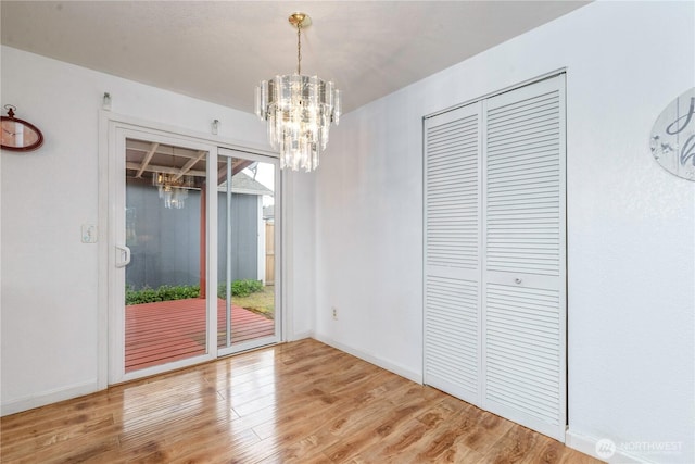 727 Salzburg Ln SE, Olympia, WA 98513 - unfurnished dining area with a chandelier, wood finished floors, and baseboards