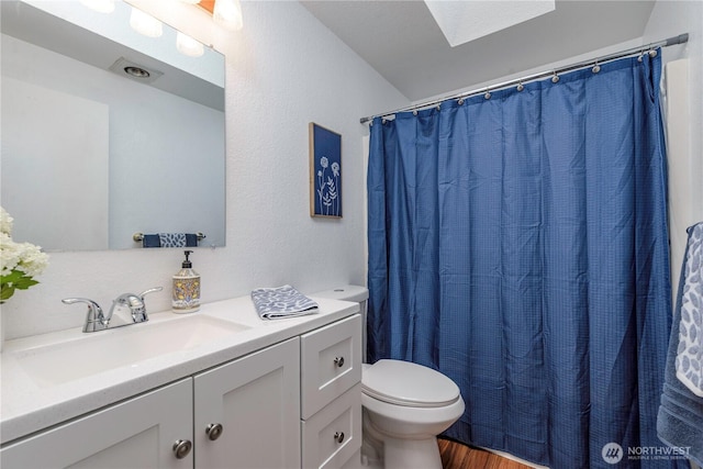 727 Salzburg Ln SE, Olympia, WA 98513 - bathroom featuring toilet, wood finished floors, vanity, and a skylight