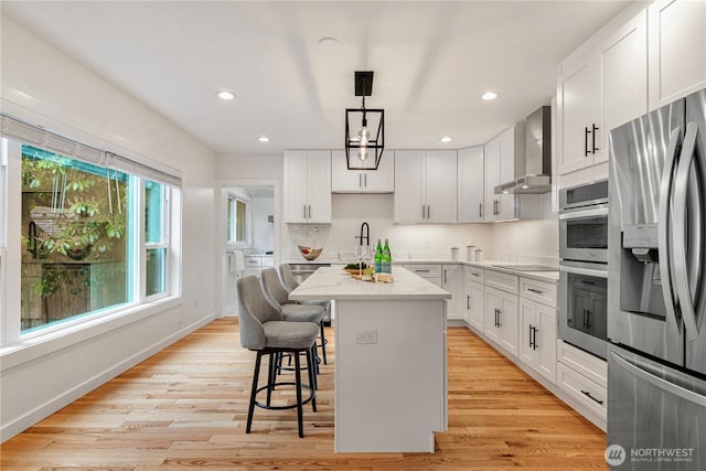 2333 NE 94th St, Seattle, WA 98115 - kitchen with stainless steel appliances, wall chimney range hood, a center island, a kitchen breakfast bar, and white cabinetry