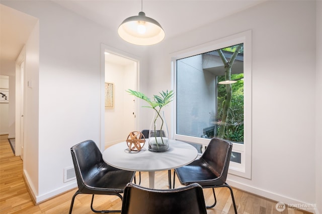 dining room with baseboards and light wood finished floors
