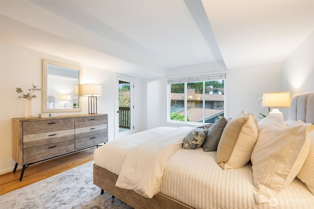 bedroom with wood finished floors and access to exterior