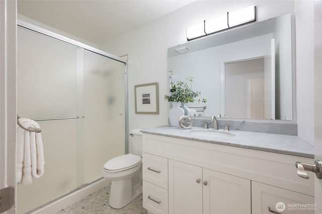 bathroom with a stall shower, toilet, and vanity