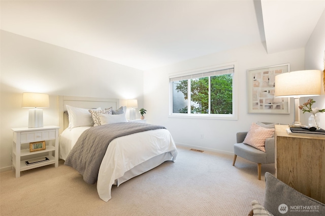 bedroom with light colored carpet and baseboards
