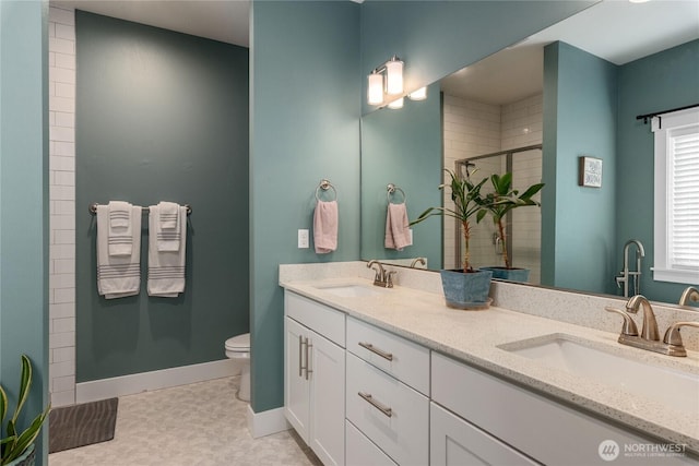 210 E Cedarland Ln, Allyn, WA 98524 - bathroom featuring a shower stall, toilet, baseboards, double vanity, and tile patterned floors