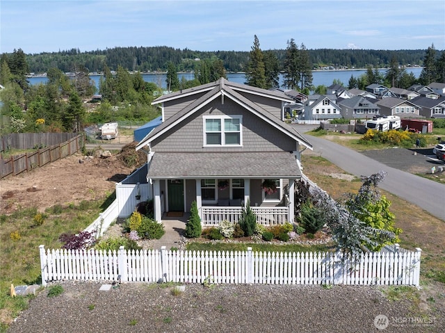 210 E Cedarland Ln, Allyn, WA 98524 - view of front of house featuring a porch, a water view, a fenced front yard, and a forest view