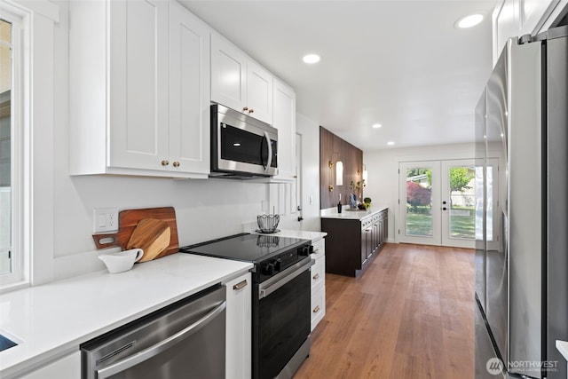 3009 Heath Ct, Steilacoom, WA 98388 - kitchen featuring appliances with stainless steel finishes, white cabinets, light countertops, light wood-style floors, and recessed lighting