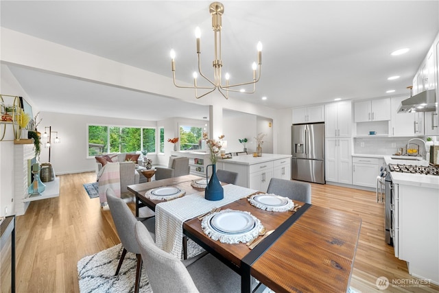 dining space featuring a chandelier, light wood-style flooring, and recessed lighting