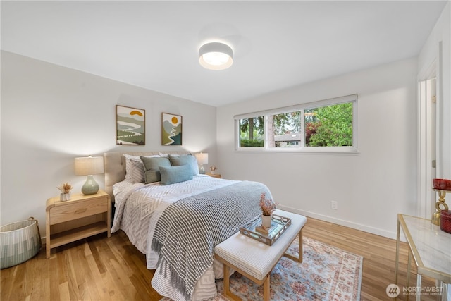 bedroom with light wood-style flooring and baseboards