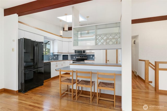 1006 N 36th St, Renton, WA 98056 - kitchen featuring black appliances, white cabinetry, light wood-style floors, and a peninsula