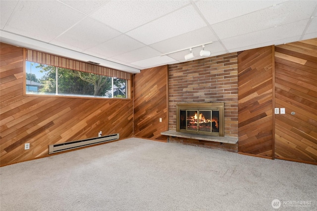 1006 N 36th St, Renton, WA 98056 - unfurnished living room with a baseboard radiator, wood walls, carpet floors, rail lighting, and a fireplace
