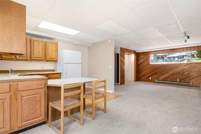 1006 N 36th St, Renton, WA 98056 - kitchen featuring freestanding refrigerator, wood walls, baseboard heating, light colored carpet, and a sink