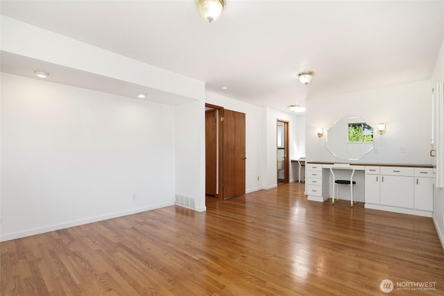 1006 N 36th St, Renton, WA 98056 - unfurnished living room featuring light wood-style floors, a desk, and baseboards