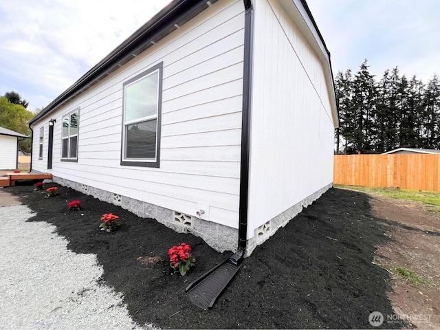 view of home's exterior with fence and crawl space