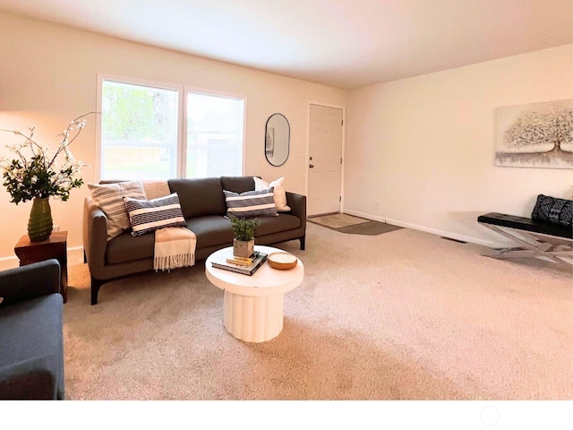 carpeted living area featuring baseboards