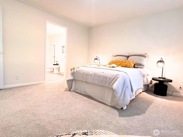 bedroom featuring carpet floors, baseboards, and ensuite bathroom