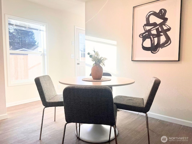 dining space with wood finished floors and baseboards