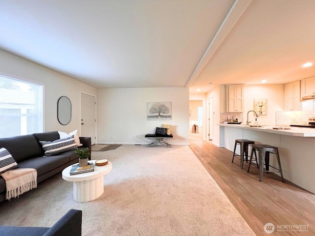 living room with recessed lighting, light wood-style flooring, and baseboards