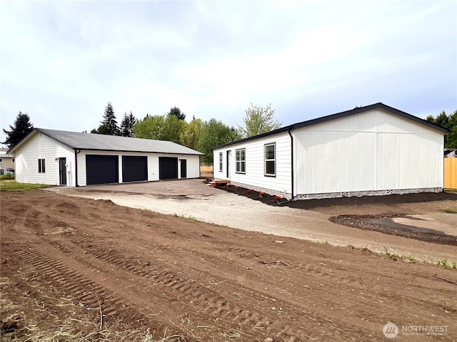 view of front of property featuring a garage and an outdoor structure