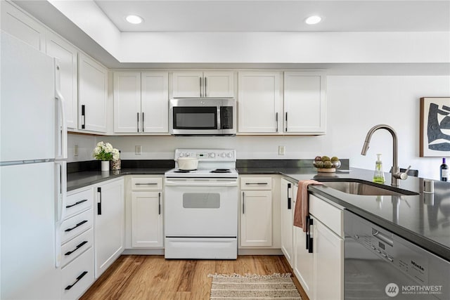 9222 Roosevelt Way NE Unit 302, Seattle, WA 98115 - kitchen with white appliances, dark countertops, light wood-style floors, recessed lighting, and white cabinets