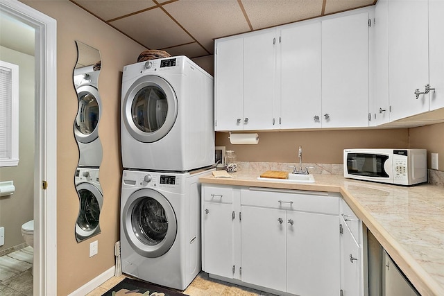 laundry area featuring estacked washer and dryer and cabinet space