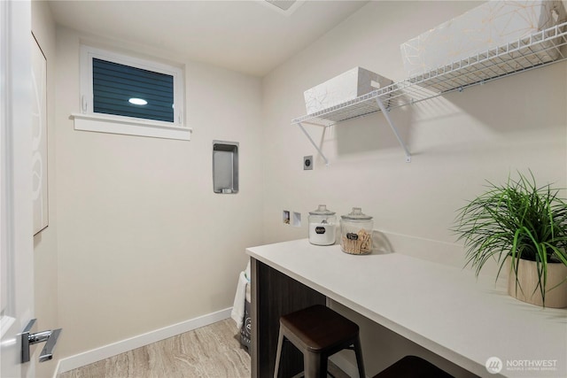 clothes washing area with hookup for an electric dryer, light wood finished floors, baseboards, and washer hookup