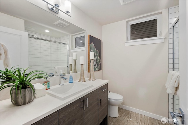bathroom featuring toilet, a tile shower, baseboards, vanity, and marble finish flooring