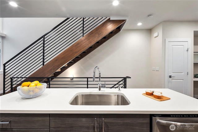 kitchen with dishwasher, a sink, recessed lighting, dark brown cabinetry, and light countertops