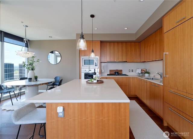10700 NE 4th St Unit 2710, Bellevue, WA 98004 - kitchen featuring appliances with stainless steel finishes, modern cabinets, light countertops, a kitchen island, and a kitchen breakfast bar