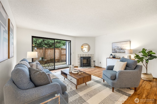 1820 SW 318th Pl Unit 26D, Federal Way, WA 98023 - living room with light wood-style floors, a textured ceiling, and a tile fireplace