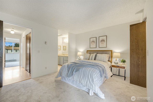1820 SW 318th Pl Unit 26D, Federal Way, WA 98023 - bedroom featuring light colored carpet, a baseboard heating unit, a textured ceiling, and ensuite bathroom