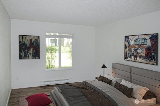 bedroom with baseboard heating, wood finished floors, a textured ceiling, and baseboards