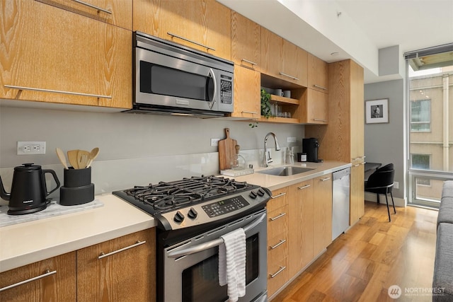 2911 2nd Ave Unit 411, Seattle, WA 98121 - kitchen with appliances with stainless steel finishes, a sink, light wood finished floors, light countertops, and open shelves