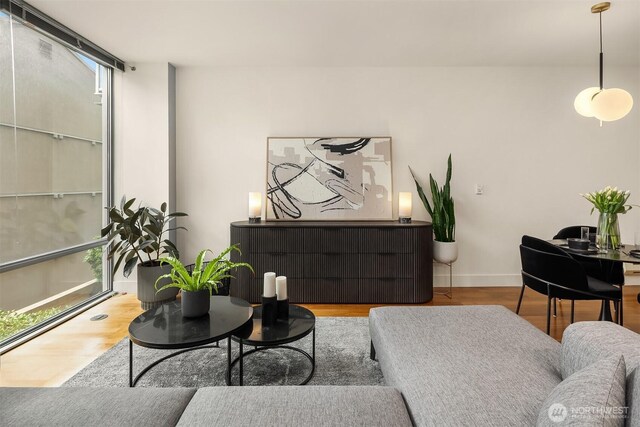 2911 2nd Ave Unit 411, Seattle, WA 98121 - living area with wood finished floors, baseboards, plenty of natural light, and radiator heating unit