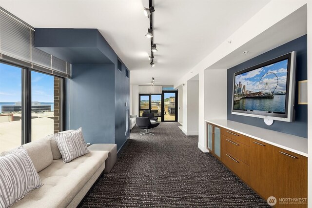2911 2nd Ave Unit 411, Seattle, WA 98121 - corridor featuring dark carpet, baseboards, and rail lighting