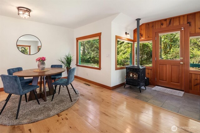 11607 SW Cove Rd, Vashon, WA 98070 - dining area featuring baseboards, a wood stove, and light wood-type flooring