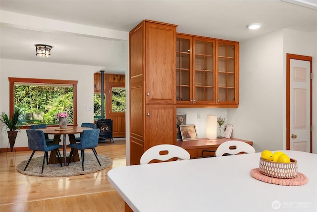 11607 SW Cove Rd, Vashon, WA 98070 - kitchen featuring a wood stove, brown cabinets, light wood-type flooring, glass insert cabinets, and recessed lighting