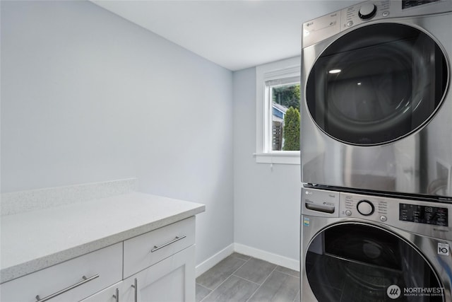 9348 54th Ave S, Seattle, WA 98118 - washroom featuring stacked washer / drying machine, baseboards, and cabinet space