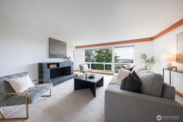 living room featuring carpet floors, a textured ceiling, and a fireplace