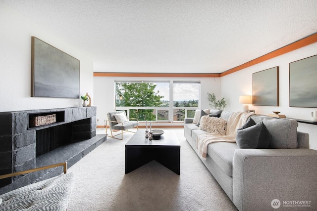 carpeted living room featuring a premium fireplace and a textured ceiling