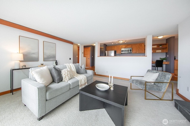 living area featuring baseboards and light carpet