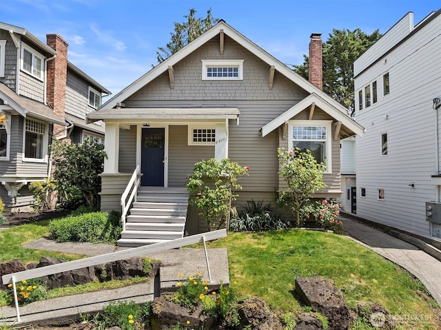 craftsman house with a porch and a front lawn