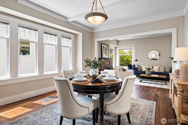 dining space with dark wood-style flooring, crown molding, beam ceiling, and baseboards