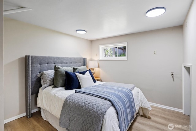 bedroom with wood finished floors and baseboards